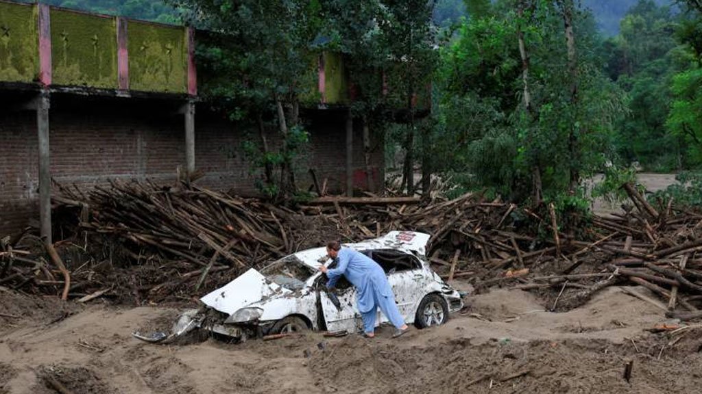 A man watching hi devastated car during floods 2025